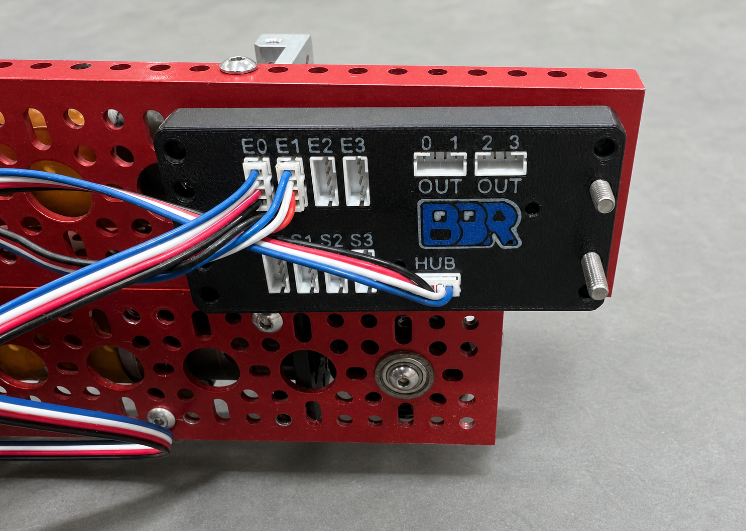 The Expander mounted on a robot chassis rail, with encoder cables running into the E0 and E1 ports and a single cable from the HUB port back to the robot controller.